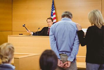 image of a man being represented by a female court appointed employee in front of a judge