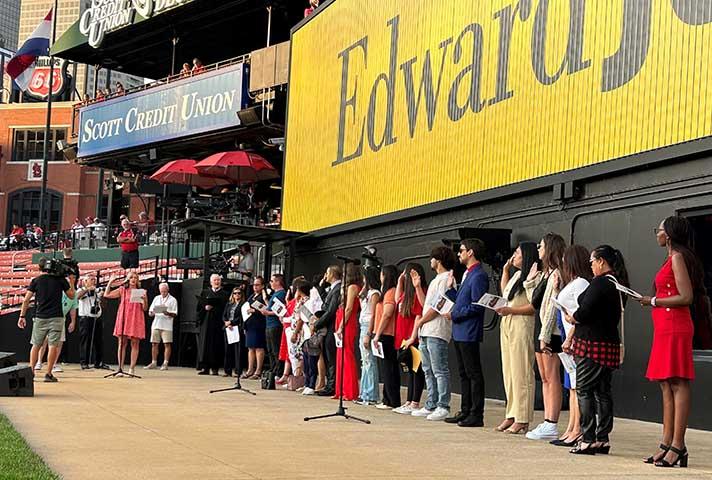New U.S. citizens recite the Oath of Allegiance during a naturalization ceremony at Busch Stadium in St. Louis.
