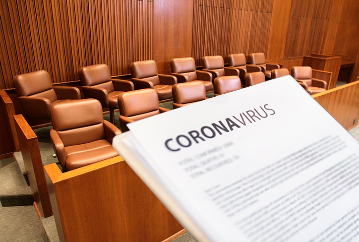 Image of a courtroom with someone holding a piece of paper with the word coronavirus printed.
