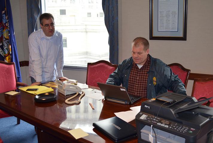 District Court Executive Edward A. Friedland and Chief Probation Officer Michael Fitzpatrick work in a makeshift command center to alert employees and jurors about court closures and restoring courthouse operations.