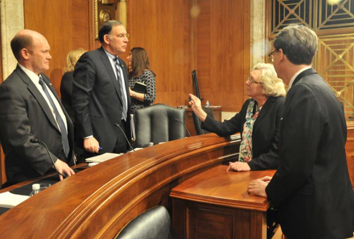 Judge Julia S. Gibbons, Budget Committee chair, speaks with Sen. Chris Coons (D-Del.), left, and Sen. John Boozman (R-Ark.). They are, respectively, ranking minority member and chair of the Senate Appropriations Subcommittee on Financial Services and Gene