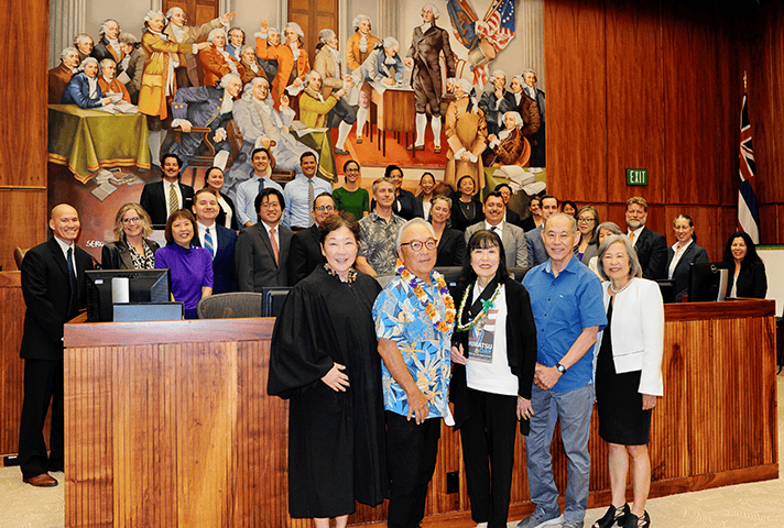 U.S. District Judge Leslie E. Kobayashi stands alongside Fred Korematsu’s daughter and three of his attorneys during a special program at the federal courthouse in Honolulu. Volunteers for the program are also pictured.