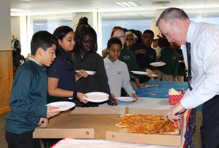 In Hartford, Connecticut, Tom Ring, law clerk to Senior District Judge Dominic J. Squatrito, hands out pizza to students of the Robert J. O'Brien STEM Academy.