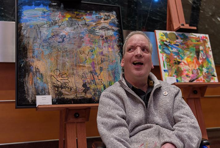 Artist Bill Crane poses in front of his artwork on display at the Diana E. Murphy U.S. Courthouse in Minneapolis.