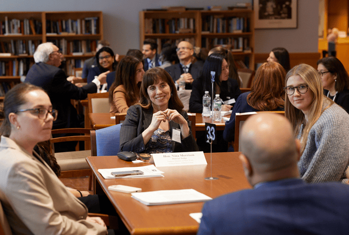 Participants share their interests in the law with District Judge Nina R. Morrison during a New York City roundtable session.