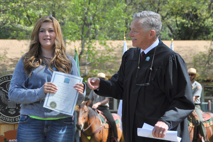 Michael J. Seng, a magistrate judge based within Yosemite National Park, congratulates essay contest winner Lilly Lessley.  