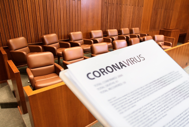 Image of a courtroom with someone holding a piece of paper with the word coronavirus printed.