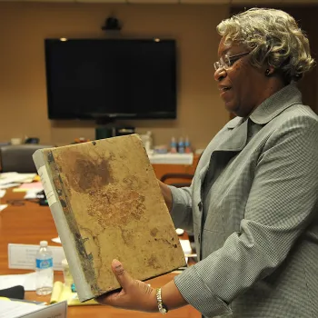 Judge Wilma A. Lewis, chief judge of the District Court of the Virgin Islands, opens the book. 