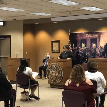 Chief Judge Julie A. Robinson, of the District of Kansas, speaks to immigrants at a naturalization ceremony. 