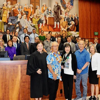 U.S. District Judge Leslie E. Kobayashi stands alongside Fred Korematsu’s daughter and three of his attorneys during a special program at the federal courthouse in Honolulu. Volunteers for the program are also pictured.