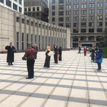 New citizens, each standing on a marked spot, take their oaths in front of the federal courthouse in Minneapolis. 