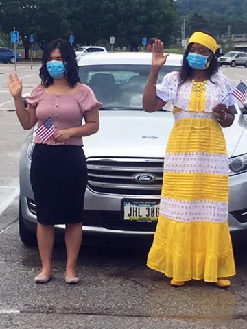Two women take their oaths in a parking lot outside the Principal Park baseball stadium in Des Moines Iowa.
