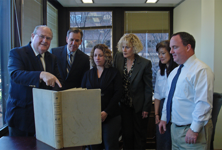 Michael Kunz, left, Clerk of the Eastern District of Pennsylvania, points to a book with handwritten docket entries that he worked with in the early 1960s. Kunz was among the federal courts' pioneers in adopting the online PACER information service. With 
