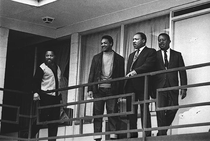 Shortly before he was slain on April 4, 1968, Martin Luther King, Jr., is flanked outside his motel room by Jesse Jackson and Ralph Abernathy. 