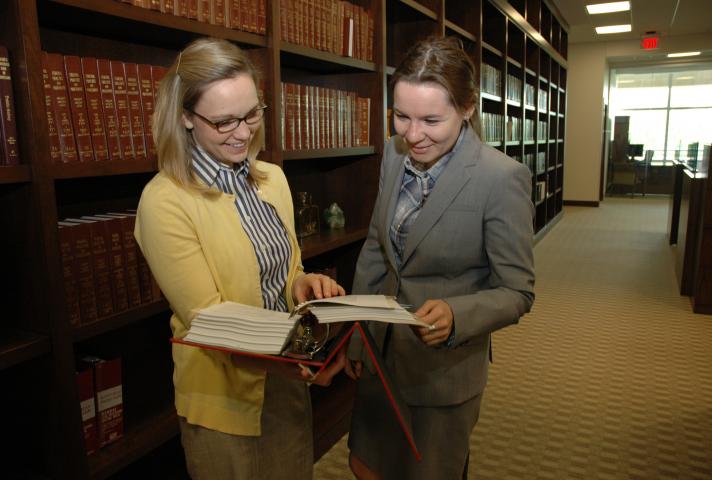 A central bookcase saves space by providing one set of volumes for judges and staff. Here, law clerks Mallory Montgomery and Zina Lapidus review a book.