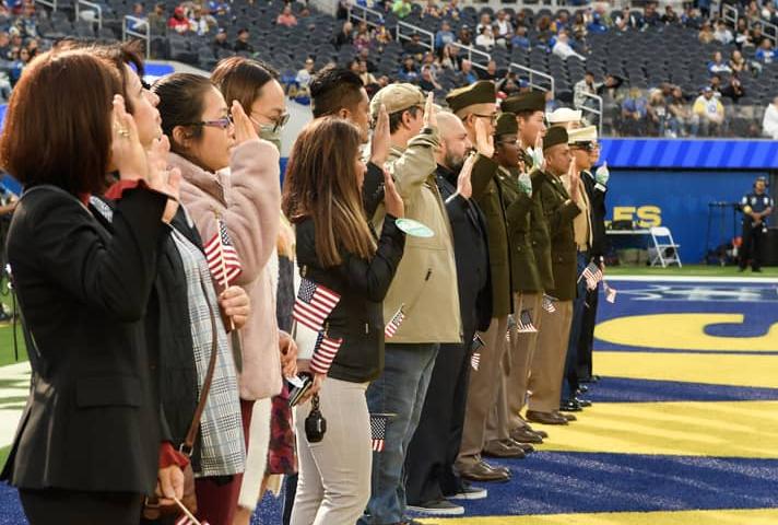 New citizens recite the Oath of Allegiance on the football field before a Los Angeles Rams game. 