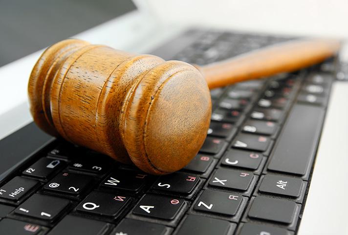 Image of a gavel laying on a laptop keyboard.