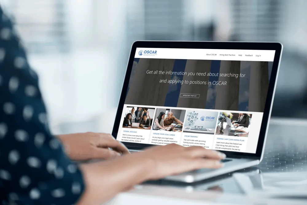 Employee sitting at laptop with the OSCAR website displayed