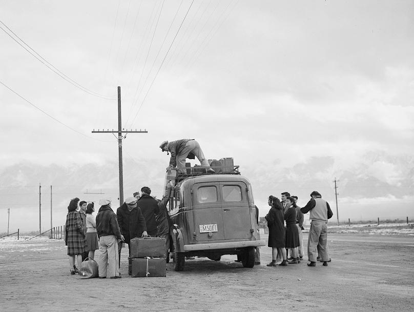 Internees wait to be trucked to the Manzanar War Relocation Center, in California.