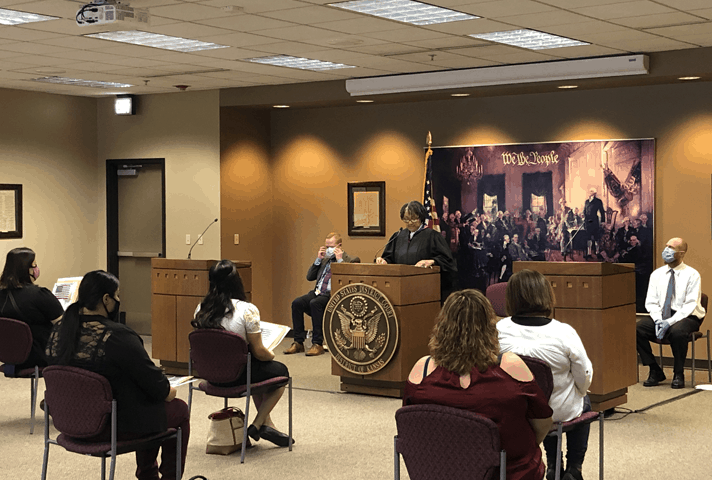 Chief Judge Julie A. Robinson, of the District of Kansas, speaks to immigrants at a naturalization ceremony. 