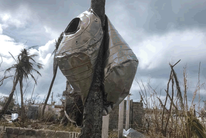 A water catchment tank was swept up by the forceful winds of Super Typhoon Yutu and crushed around a coconut tree not far from the courthouse in the Northern Mariana Islands.