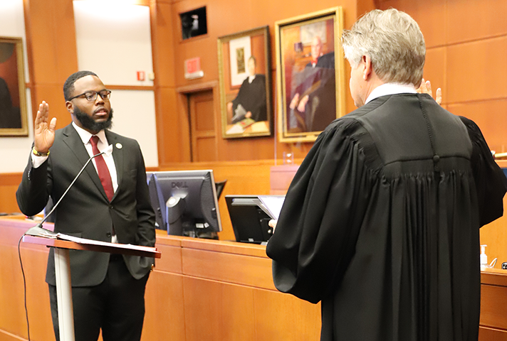 A federal judge swears in new a probation and pretrial services officer in a federal courtroom..