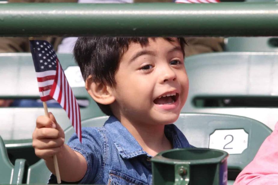 A child waives a flag from the stands at Wrigley Field in celebration. Photo credit: Jim Slonoff