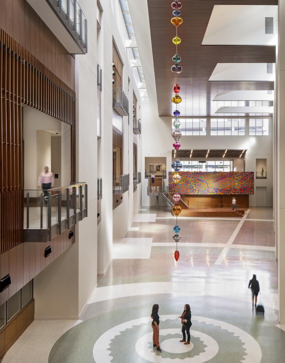 The sculpture is made of a string of colorful glass forms that drop form the atrium ceiling.