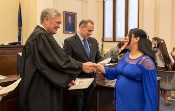 Senior Judge D. Brock Hornby gives a certificate of citizenship. 